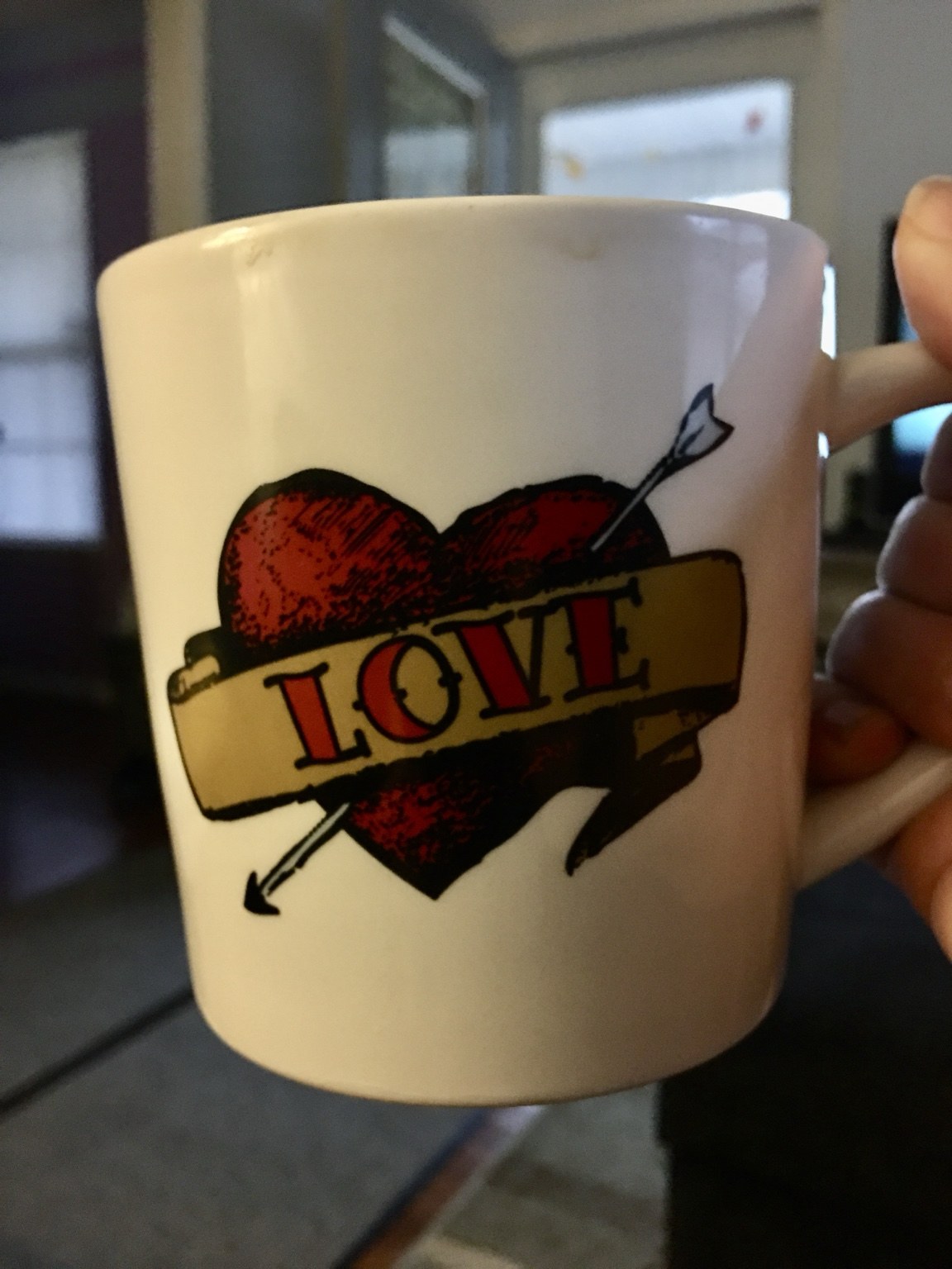 A white mug with a red heart and Love banner